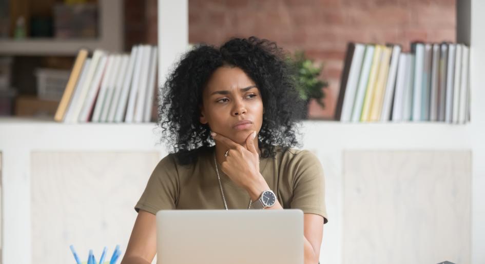 person thinking in front of a laptop