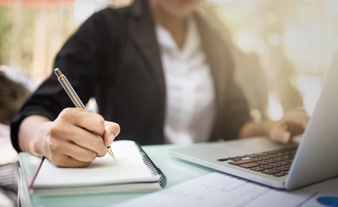 admission professional takes notes at a laptop