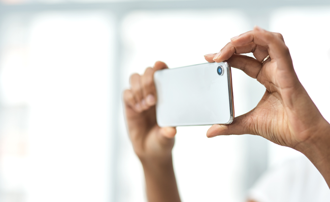 Hands holding mobile phone to use as a camera