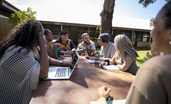 A group of students sits together around a table