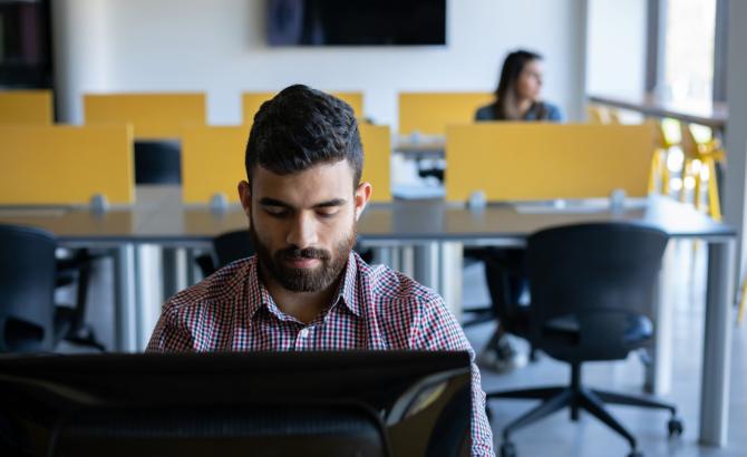 A man types on a computer in a test center environment
