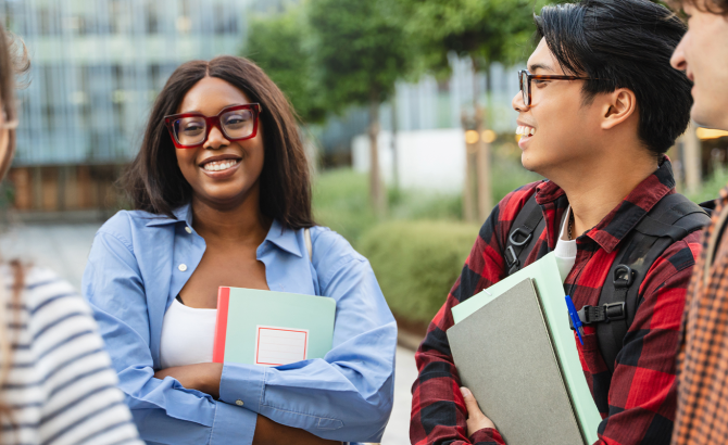 A group of students stands in a group, talking