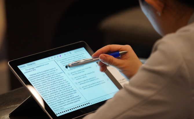 A test taker using a stylus to interact with the Digital LSAT