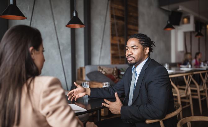 A man and a woman sit together during an interview