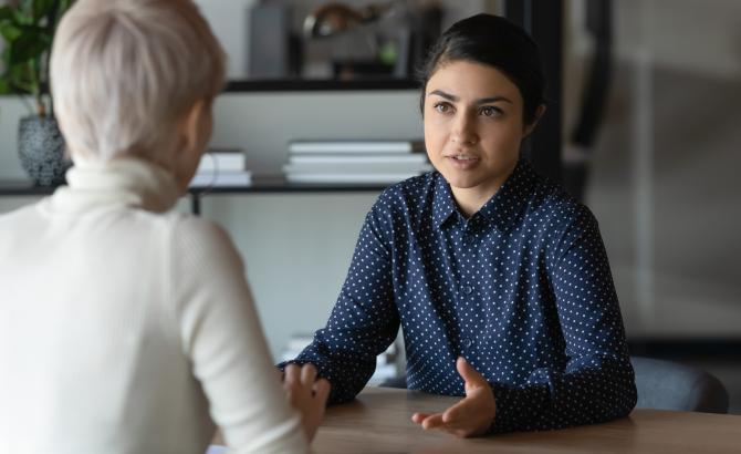 A young woman sits in a job interview with an older woman