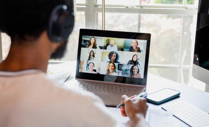 Law student with headphones on, taking online course at laptop