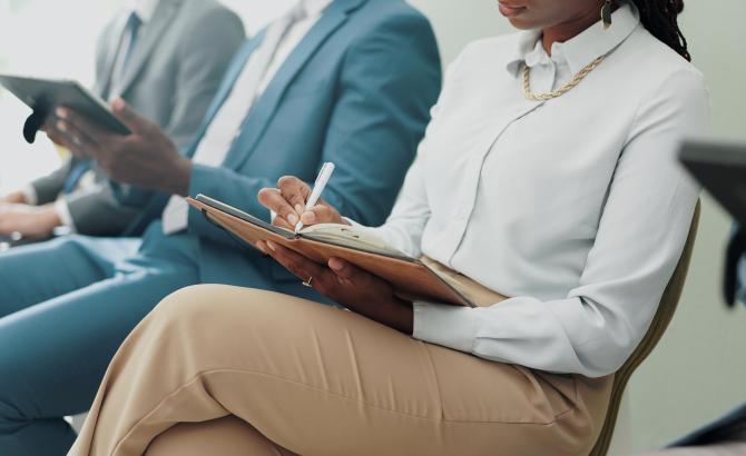 People sit in a line waiting for a job interview
