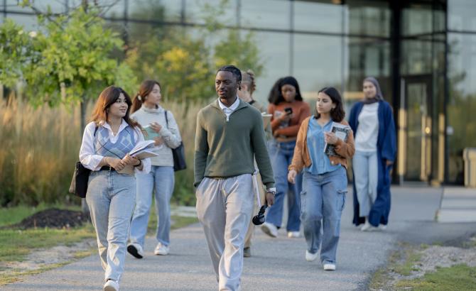 A group of students walks across a college campus