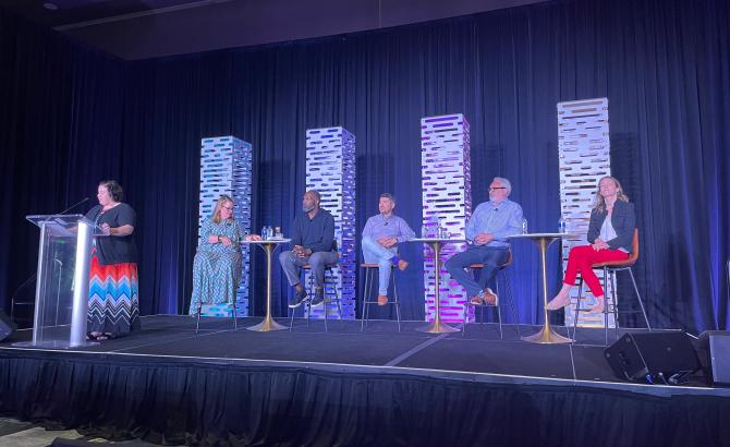 The “Marketing in a Post-Pandemic World” session is shown with speakers on the stage. Full caption is below.