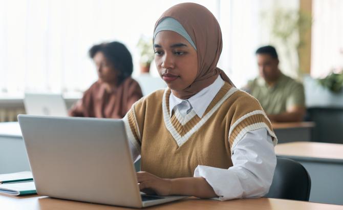 a young woman types on a laptop