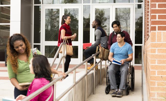 Diverse group of students on ramp and staircase to building.