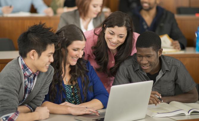 Students gathered around a laptop.